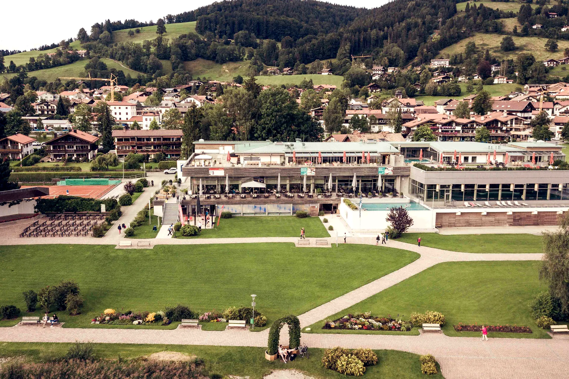 Luftbild vom Studio medius in Schliersee mit dem Park am See davor und dem Ort dahinter